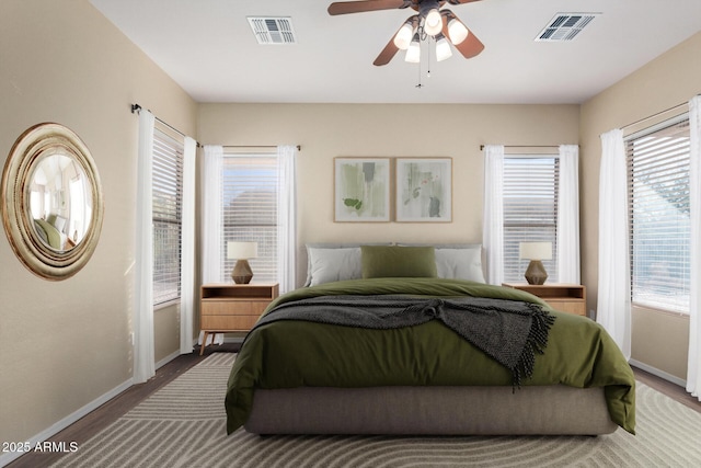 bedroom with wood-type flooring, multiple windows, and ceiling fan