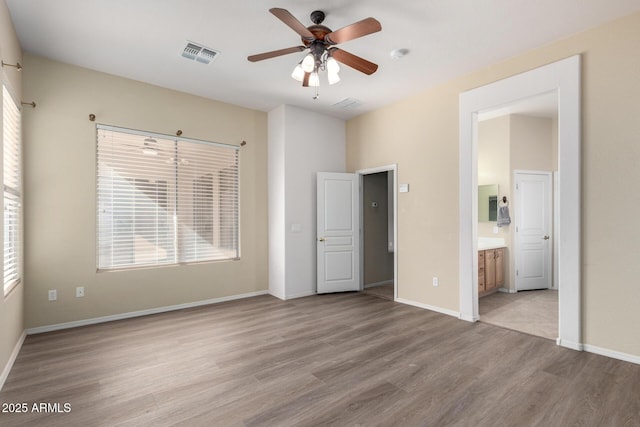 unfurnished bedroom featuring light hardwood / wood-style floors, connected bathroom, and ceiling fan