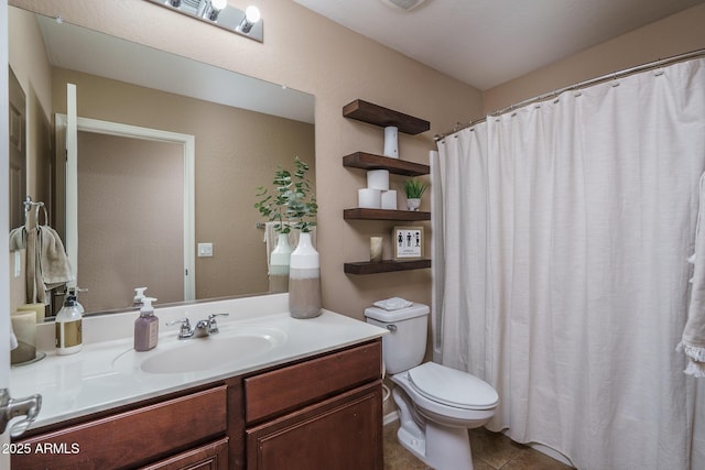 bathroom with tile patterned flooring, vanity, and toilet