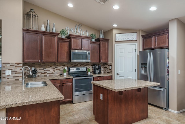 kitchen with lofted ceiling, sink, tasteful backsplash, a kitchen breakfast bar, and stainless steel appliances