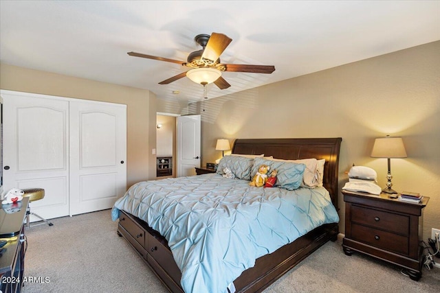 bedroom with ceiling fan, a closet, and light colored carpet