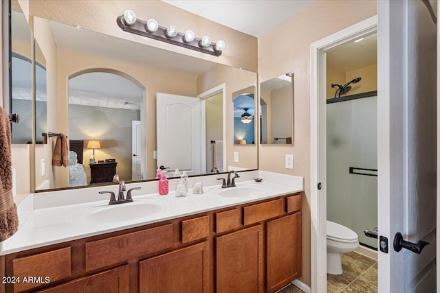 bathroom featuring tile patterned floors, vanity, toilet, and a shower with shower door