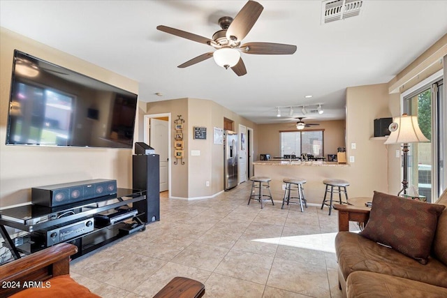 tiled living room featuring ceiling fan