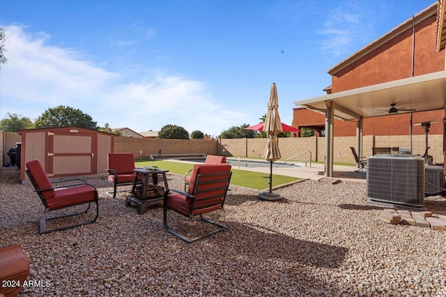 view of patio / terrace with ceiling fan, a shed, and central AC