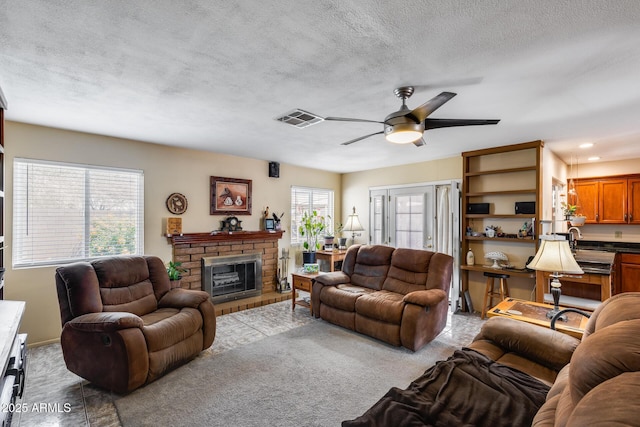 7210 W Caron Dr, Peoria, AZ 85345 - carpeted living area featuring plenty of natural light, a ceiling fan, a fireplace, a textured ceiling, and recessed lighting