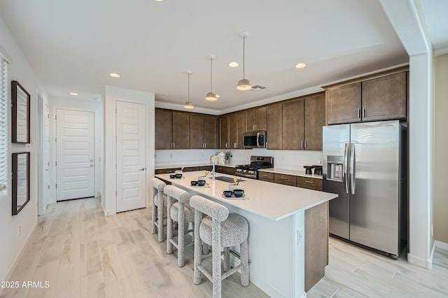 10105 E Ulysses Ave, Mesa, AZ 85212 - kitchen with stainless steel appliances, a sink, dark brown cabinetry, recessed lighting, and hanging light fixtures