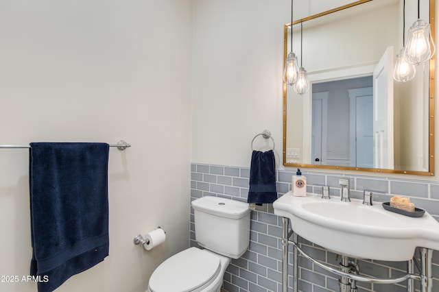 bathroom featuring tile walls and toilet