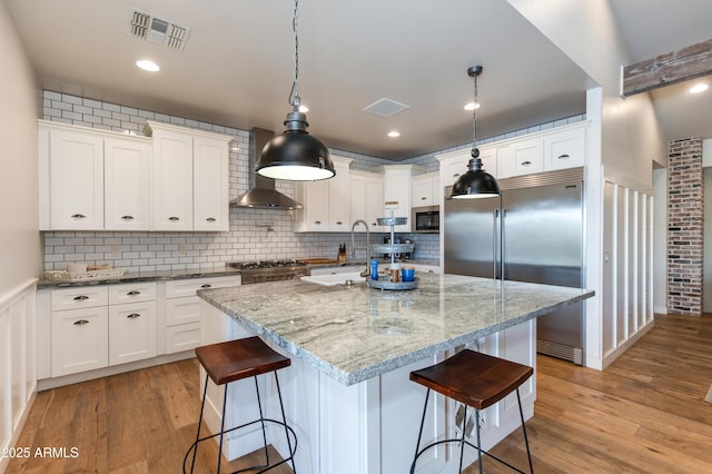 kitchen with white cabinetry, appliances with stainless steel finishes, and a center island with sink