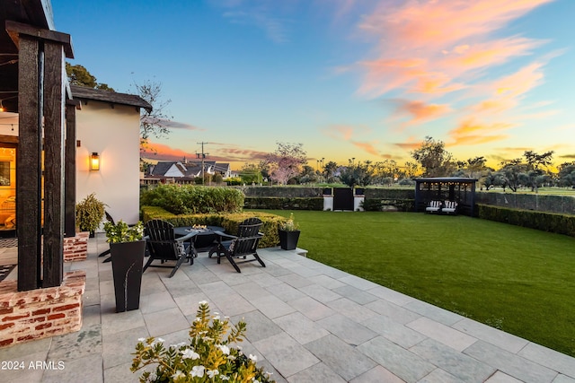 5929 E Indian School Rd, Phoenix, AZ 85018 - patio terrace at dusk with a patio area, an outdoor fire pit, and a lawn