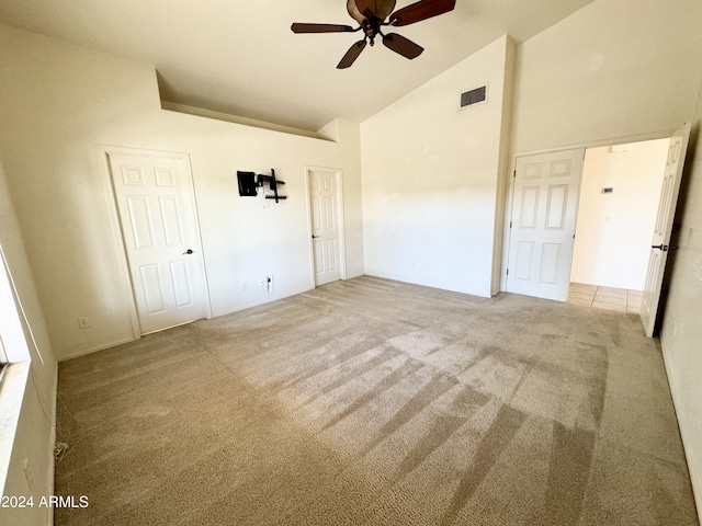 unfurnished bedroom featuring high vaulted ceiling, carpet, visible vents, and ceiling fan