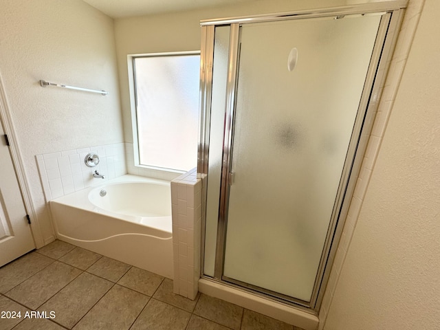 bathroom with a shower stall, a garden tub, and tile patterned floors