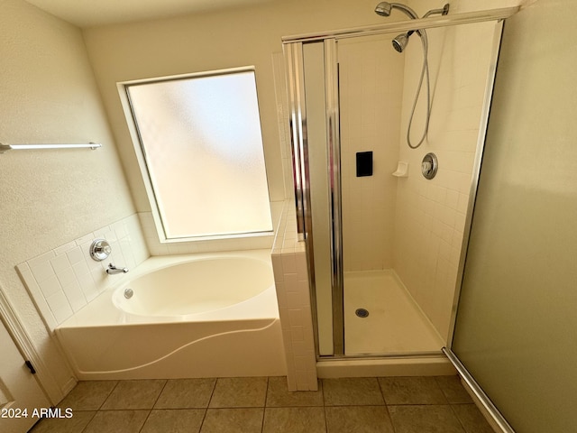 bathroom with tile patterned flooring, a garden tub, and a shower stall