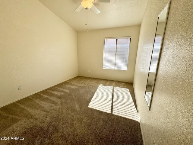 carpeted spare room with a ceiling fan, a textured wall, and a textured ceiling