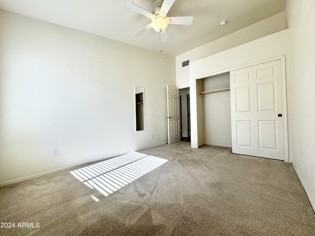 unfurnished bedroom featuring ceiling fan, a closet, visible vents, and light colored carpet