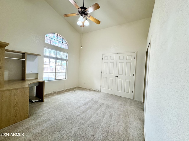 interior space featuring high vaulted ceiling, carpet flooring, and ceiling fan