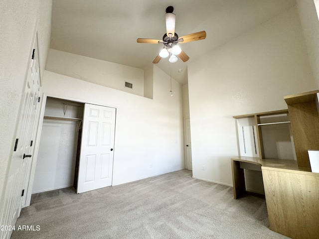 unfurnished bedroom featuring a closet, visible vents, a ceiling fan, carpet flooring, and high vaulted ceiling