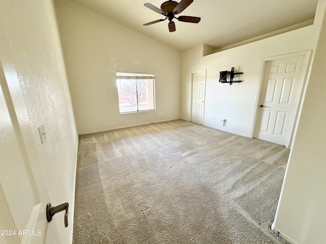 carpeted empty room with vaulted ceiling and ceiling fan