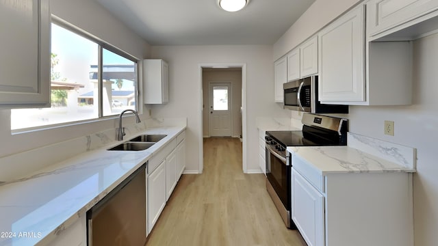 kitchen with white cabinets, stainless steel appliances, and a healthy amount of sunlight