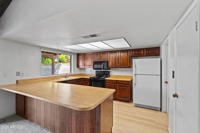 2264 S Don Carlos, Mesa, AZ 85202 - kitchen featuring black appliances, a peninsula, light countertops, light wood-style floors, and a sink