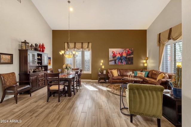 15439 E Acacia Way, Fountain Hills, AZ 85268 - dining room featuring a notable chandelier, high vaulted ceiling, plenty of natural light, and light wood-style floors