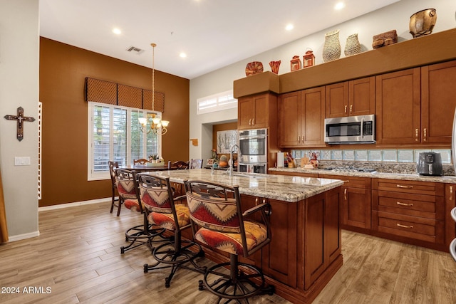 15439 E Acacia Way, Fountain Hills, AZ 85268 - kitchen featuring brown cabinets, a kitchen bar, visible vents, and appliances with stainless steel finishes