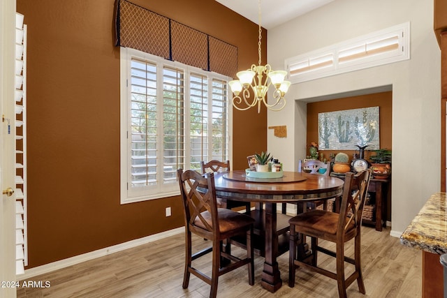 dining space featuring light hardwood / wood-style flooring, a notable chandelier, and a wealth of natural light