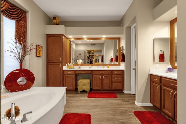 bathroom featuring vanity, hardwood / wood-style flooring, and a bathtub