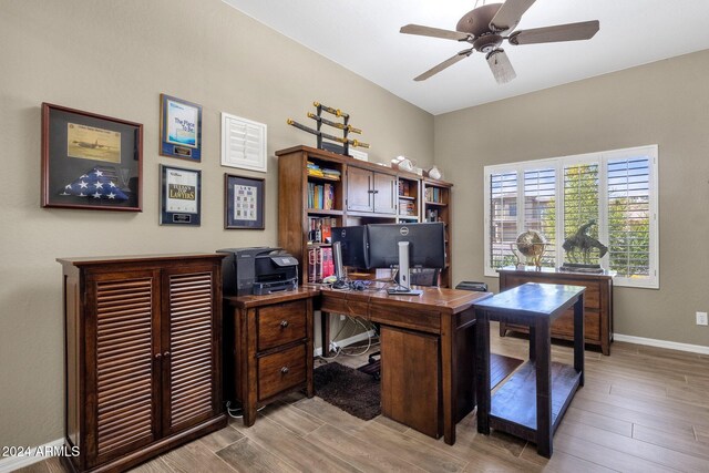 home office with light hardwood / wood-style flooring and ceiling fan