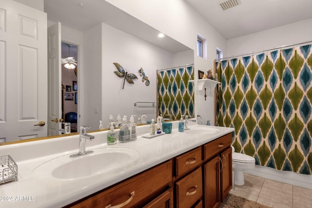 bathroom with tile patterned floors, toilet, curtained shower, vanity, and ceiling fan