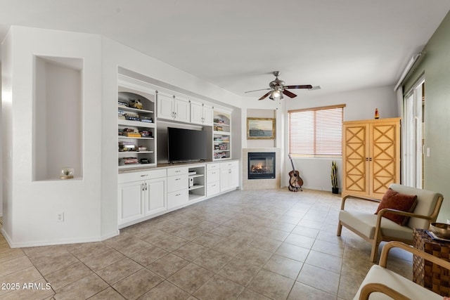 tiled living room with ceiling fan and built in features