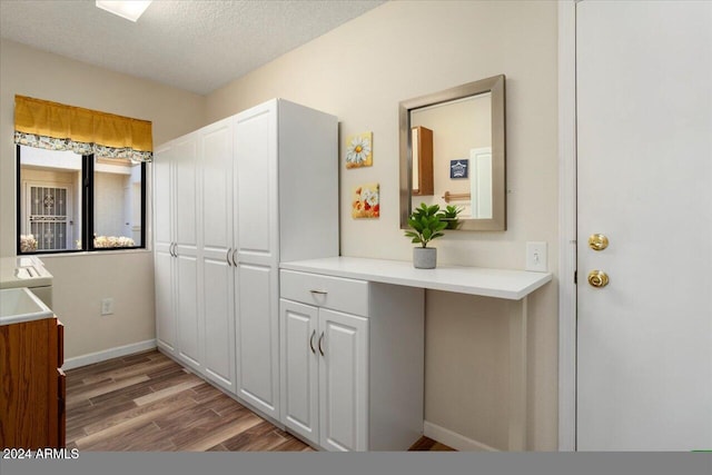 bathroom featuring wood-type flooring and a textured ceiling