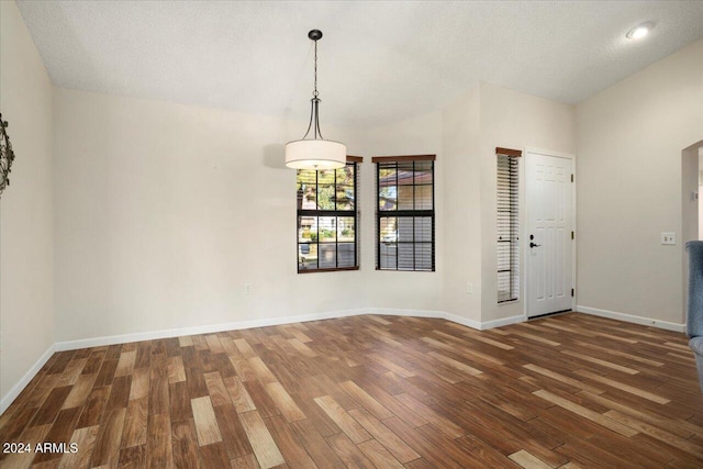 interior space with a textured ceiling, lofted ceiling, and dark hardwood / wood-style floors