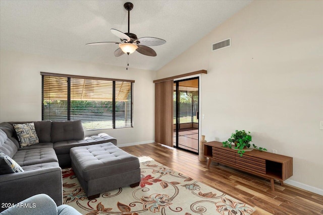 living room featuring a textured ceiling, light wood-type flooring, ceiling fan, and high vaulted ceiling