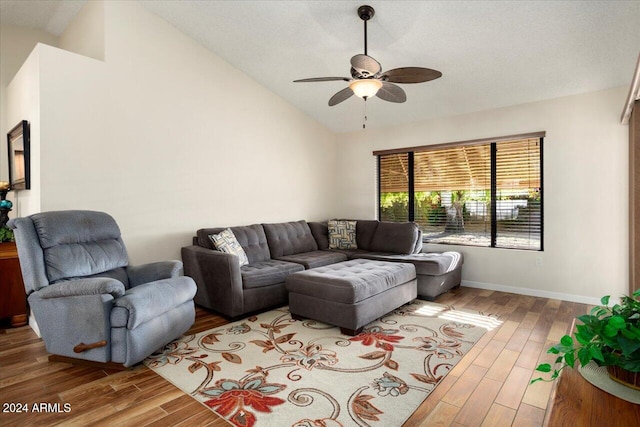 living room featuring ceiling fan, wood-type flooring, and vaulted ceiling