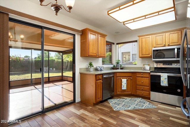 kitchen featuring appliances with stainless steel finishes, sink, and light hardwood / wood-style floors