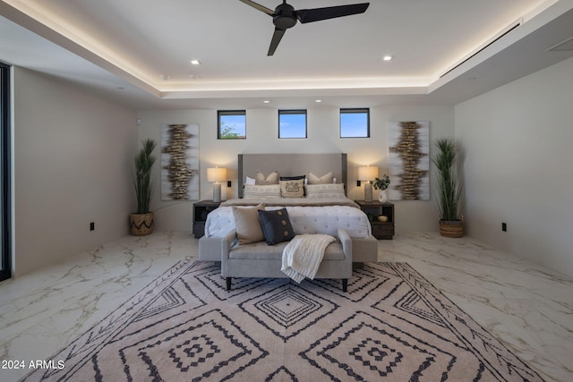 bedroom with ceiling fan and a raised ceiling