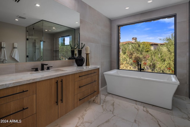 bathroom featuring vanity and shower with separate bathtub