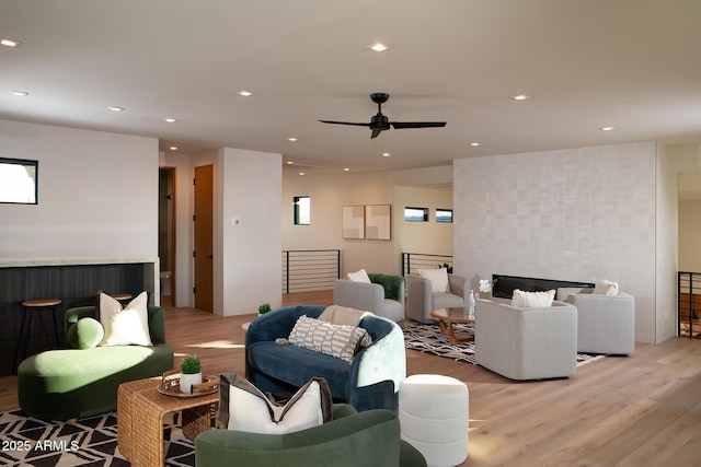 living room featuring a tile fireplace and light hardwood / wood-style floors