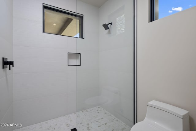 bathroom with toilet and tiled shower