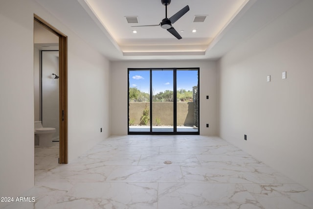 empty room with a tray ceiling and ceiling fan