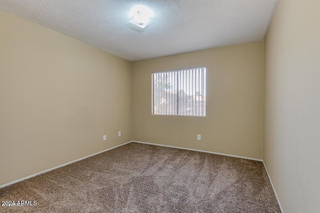 unfurnished room with carpet floors and a textured ceiling