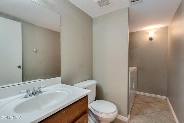 bathroom with washing machine and dryer, tile patterned flooring, vanity, and toilet