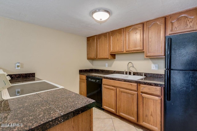 kitchen featuring black appliances, light tile patterned floors, sink, and a textured ceiling