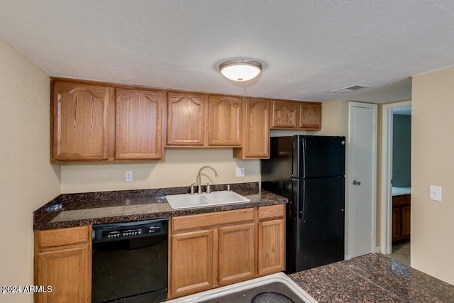 kitchen featuring black appliances, sink, and a textured ceiling