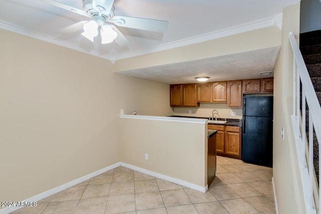 kitchen featuring light tile patterned floors, black fridge, ornamental molding, and sink