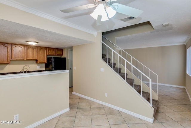 kitchen with ceiling fan, black fridge, a textured ceiling, light tile patterned floors, and ornamental molding