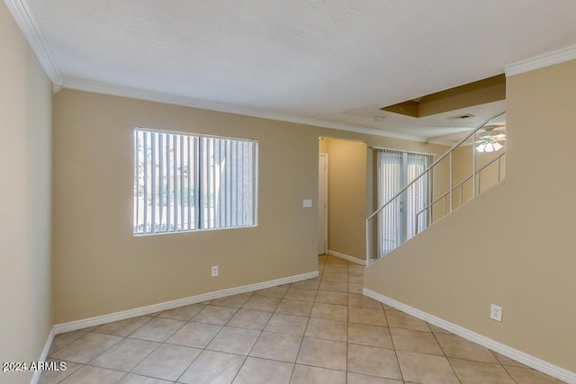 tiled empty room featuring ceiling fan and crown molding