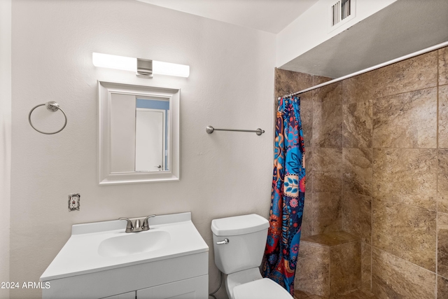 bathroom with curtained shower, vanity, and toilet