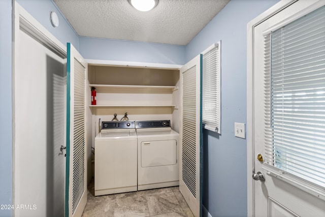 laundry area featuring washer and clothes dryer and a textured ceiling