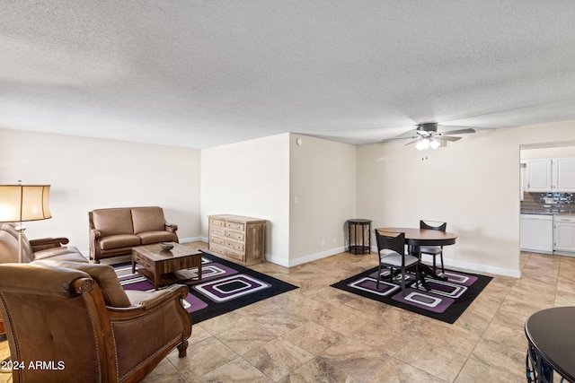 living room with a textured ceiling and ceiling fan